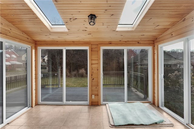 entryway featuring lofted ceiling with skylight, wood ceiling, and wooden walls