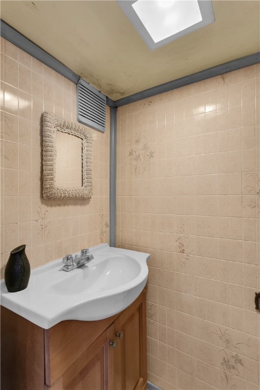 bathroom featuring vanity and tile walls