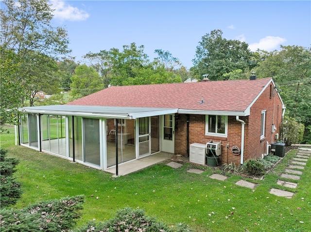 rear view of house with a yard, a sunroom, central AC, and a patio