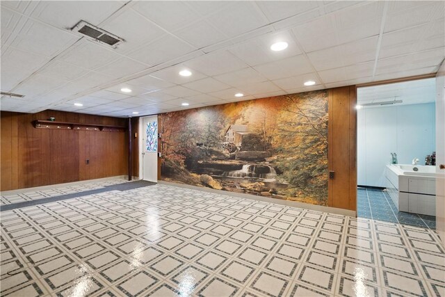 basement featuring wooden walls