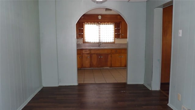 corridor featuring dark hardwood / wood-style floors, sink, and wooden walls