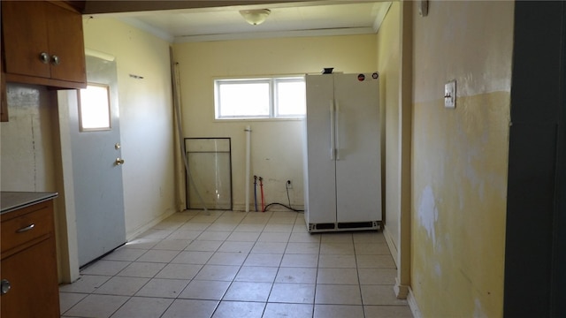 interior space with crown molding and light tile patterned floors