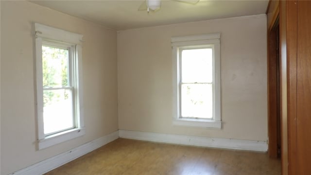 spare room with light hardwood / wood-style flooring, ceiling fan, and a wealth of natural light