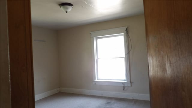 spare room with plenty of natural light and light colored carpet