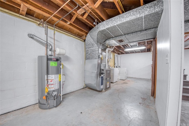 basement featuring water heater, heating unit, and washing machine and dryer