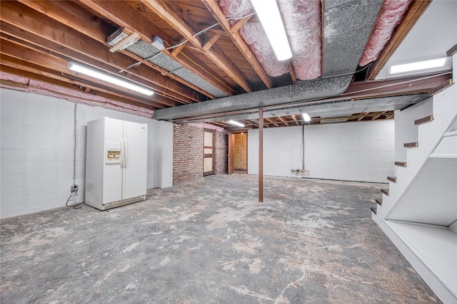 basement with white fridge with ice dispenser