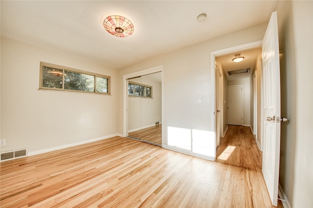 unfurnished bedroom with light hardwood / wood-style floors and a closet