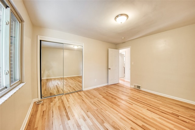 unfurnished bedroom featuring light hardwood / wood-style floors and a closet