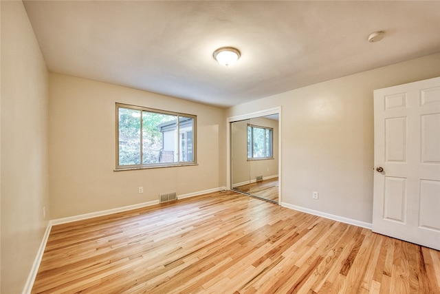 spare room featuring light wood-type flooring and plenty of natural light