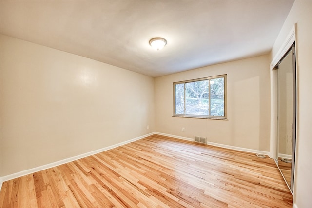 unfurnished bedroom with a closet and light hardwood / wood-style floors