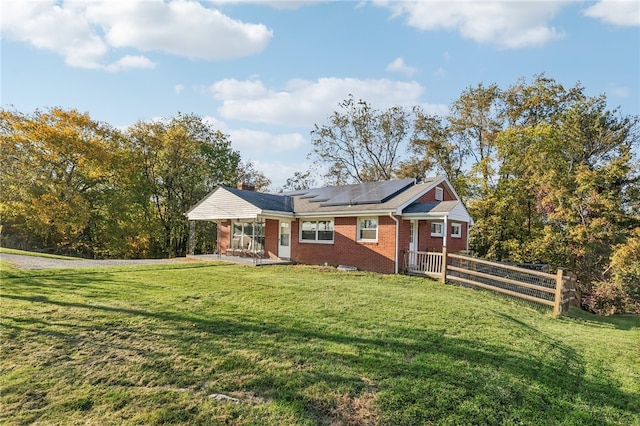 view of front of house with solar panels and a front lawn