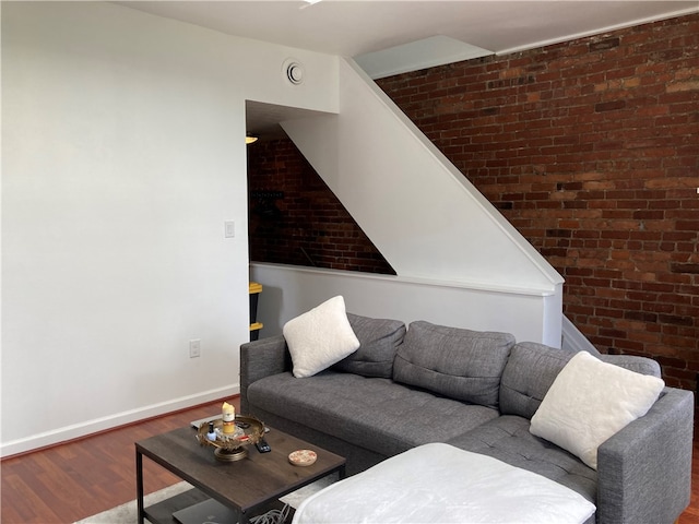 living room featuring hardwood / wood-style flooring and brick wall