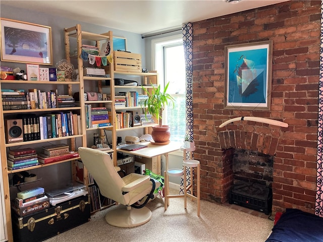 sitting room featuring brick wall, a brick fireplace, and carpet flooring