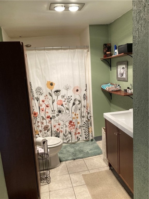 bathroom featuring toilet, vanity, tile patterned floors, and a shower with shower curtain