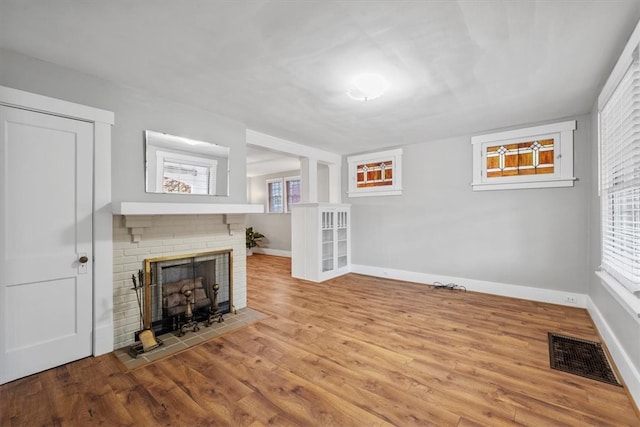 unfurnished living room with a fireplace and light hardwood / wood-style floors