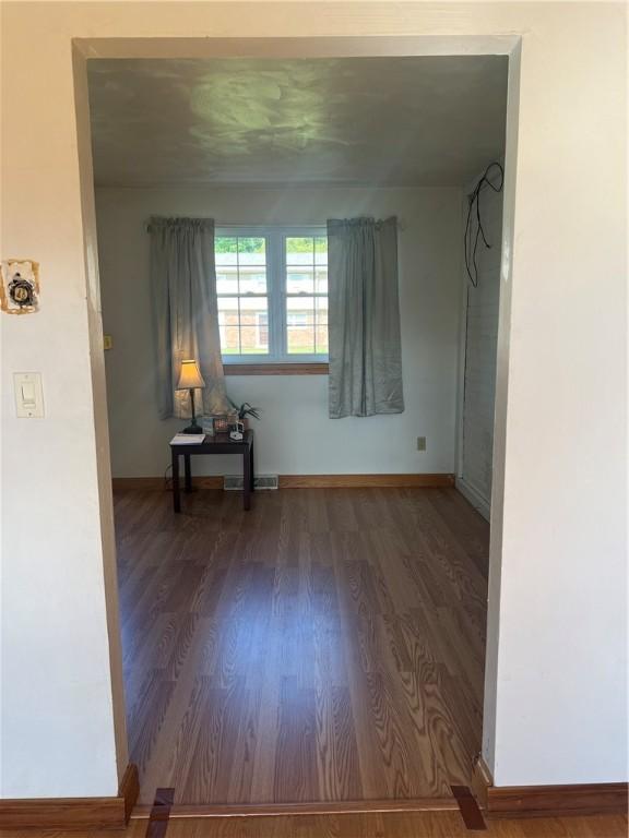 unfurnished room with dark wood-type flooring