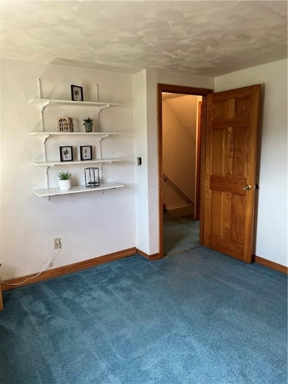 carpeted spare room featuring a textured ceiling