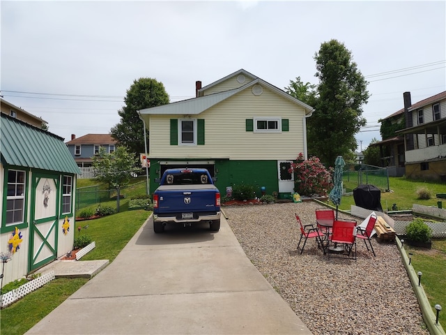 view of front of home featuring a storage unit and a front yard