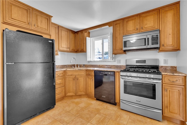 kitchen featuring black appliances, sink, and light stone counters