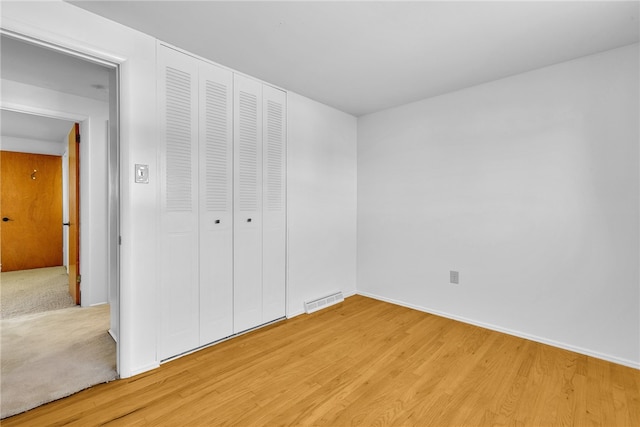 unfurnished bedroom featuring a closet and hardwood / wood-style flooring