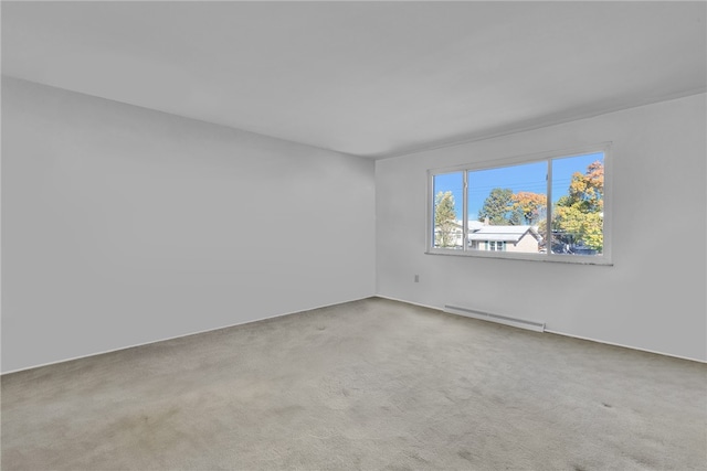 spare room featuring a baseboard heating unit and carpet