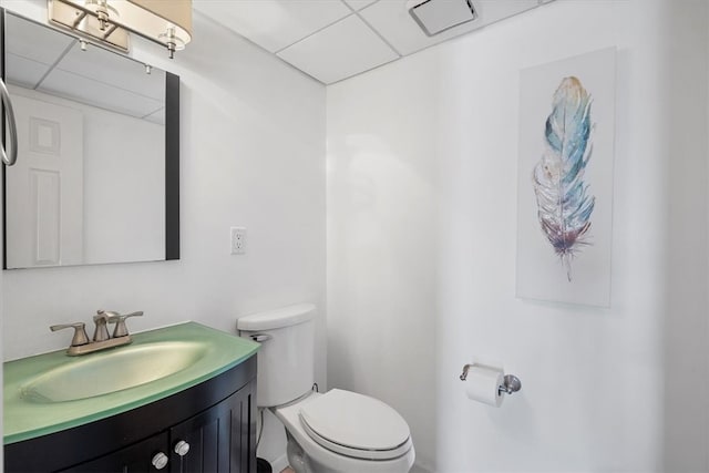 bathroom featuring vanity, a paneled ceiling, and toilet