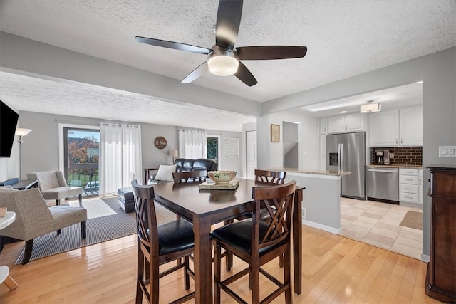 dining room with light hardwood / wood-style flooring and a textured ceiling