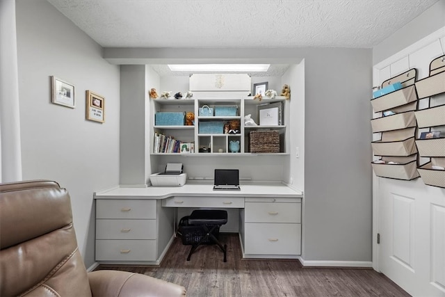 office with built in desk, a textured ceiling, and dark hardwood / wood-style flooring