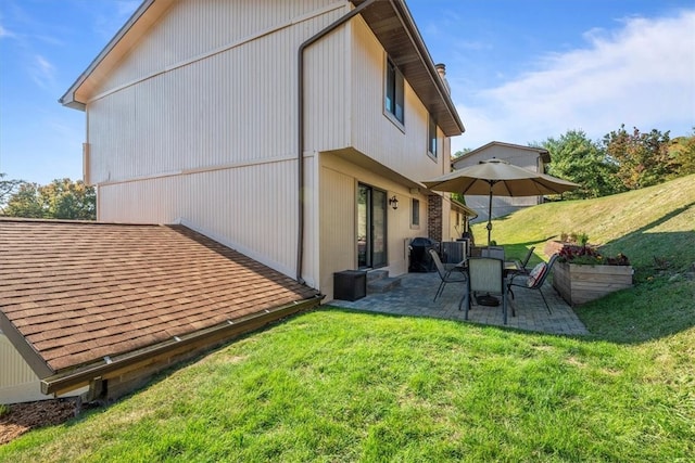 rear view of property featuring a yard and a patio area