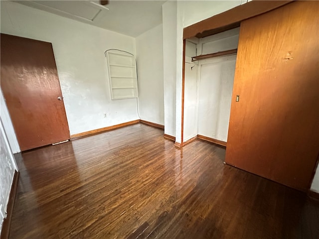 unfurnished bedroom featuring a closet and dark hardwood / wood-style flooring