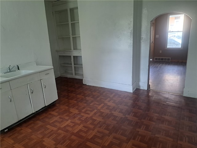 interior space with sink and dark parquet flooring