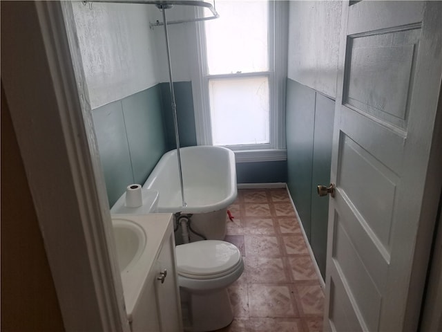 bathroom featuring vanity, toilet, and a bath