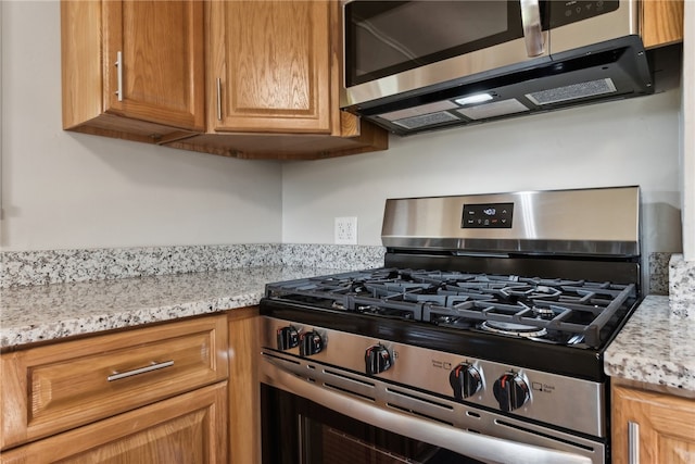 kitchen featuring light stone countertops and appliances with stainless steel finishes