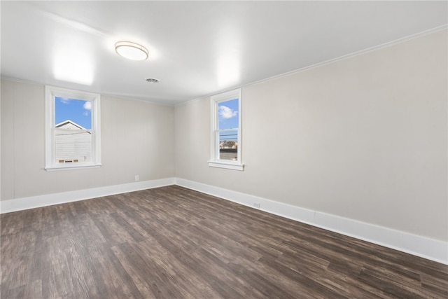 spare room featuring dark hardwood / wood-style flooring and crown molding