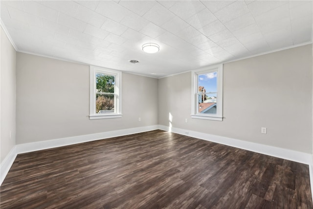 spare room featuring dark hardwood / wood-style flooring and crown molding