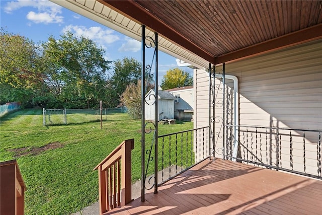 deck featuring a storage shed and a yard