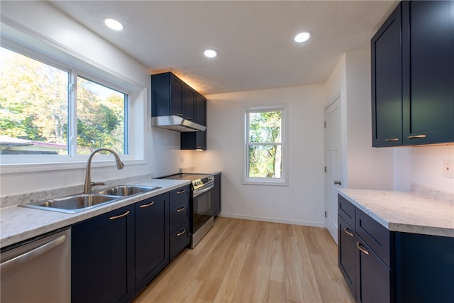 kitchen featuring light stone countertops, sink, blue cabinets, light hardwood / wood-style floors, and stainless steel appliances