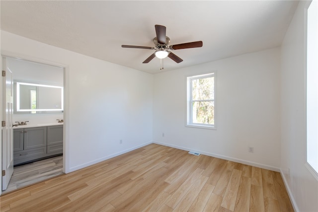 empty room with light hardwood / wood-style floors and ceiling fan