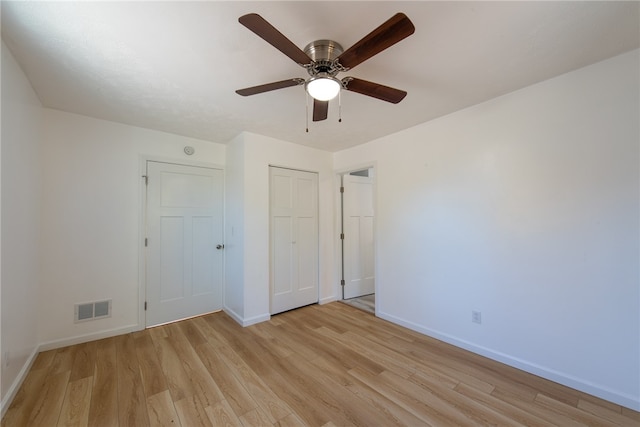 unfurnished bedroom featuring a closet, light wood-type flooring, and ceiling fan