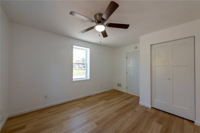 unfurnished bedroom featuring a closet, light hardwood / wood-style floors, and ceiling fan