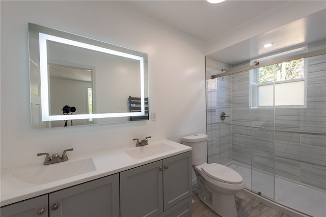 bathroom with toilet, walk in shower, vanity, and wood-type flooring