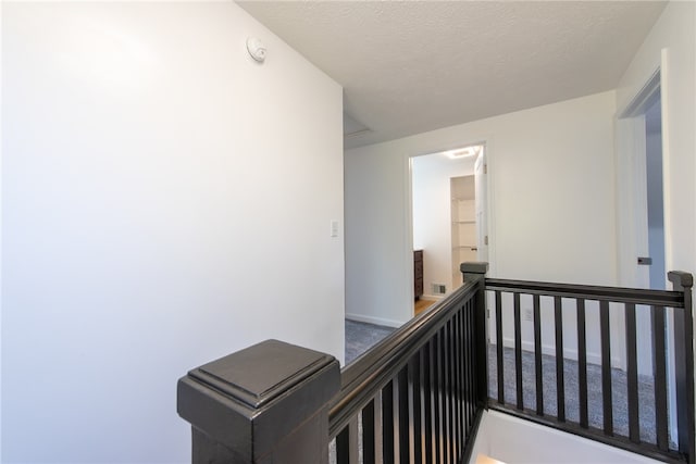 hallway with a textured ceiling