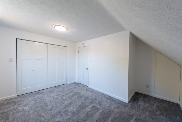 bonus room with a textured ceiling, lofted ceiling, and dark carpet