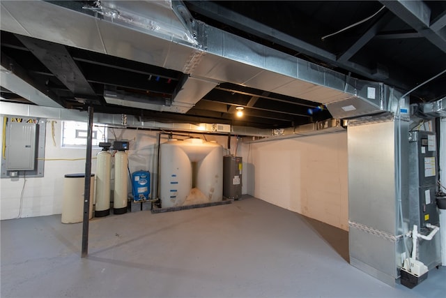 basement featuring water heater, electric panel, and heating unit