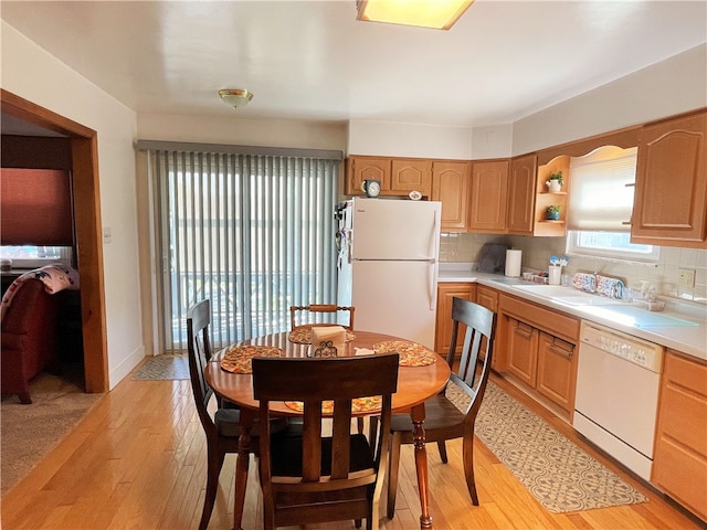 kitchen with light hardwood / wood-style floors, sink, white appliances, and backsplash