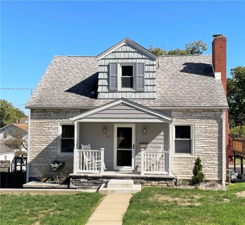 view of front of home featuring covered porch and a front lawn