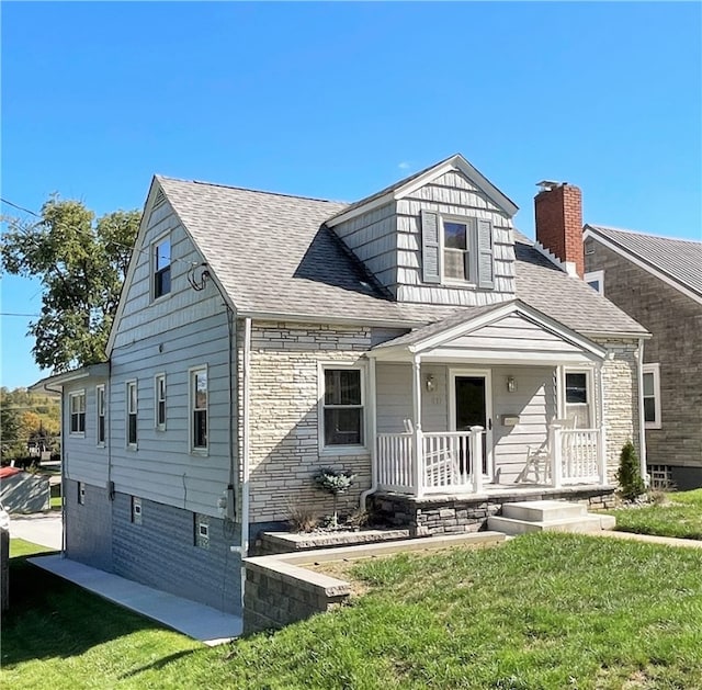 view of front of home with a porch, a garage, and a front yard