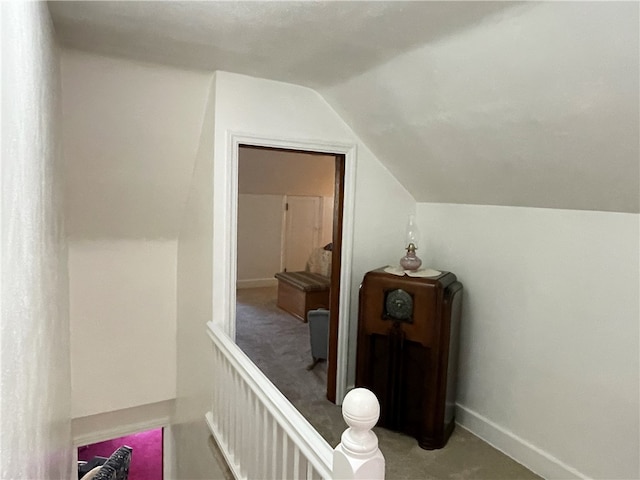 hallway with carpet and lofted ceiling