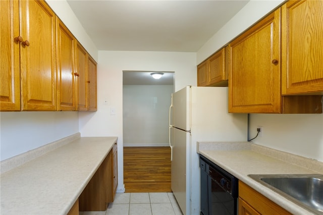 kitchen featuring sink, dishwasher, white refrigerator, and light tile patterned floors