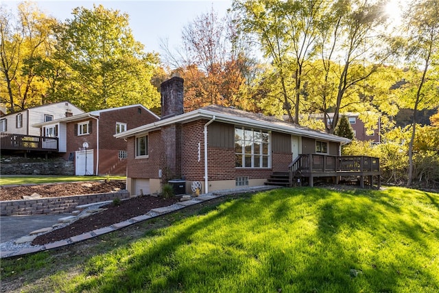 rear view of property featuring a deck and a lawn